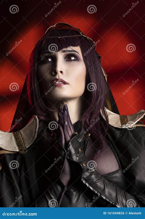 a beautiful busty cosplay girl wearing an erotic leather costume sensually cries with tears in