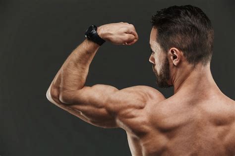 Retrato De Un Hombre Fuerte Y Guapo Flexionando Sus Bíceps Foto Gratis