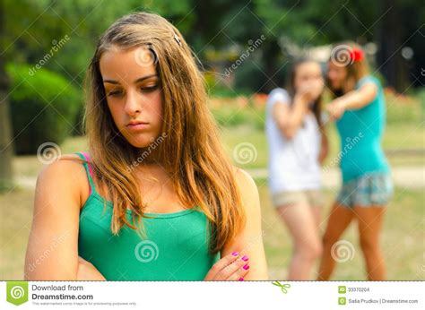 Two Teenage Girls Making Fun Of The Third Stock Photo