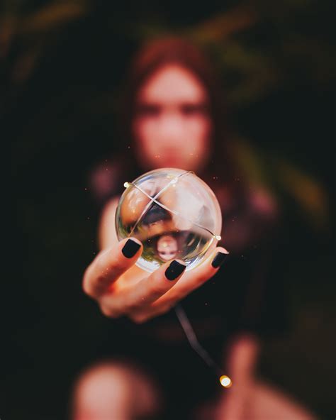 Person Holding Clear Glass Ball Using Right Hand · Free Stock Photo