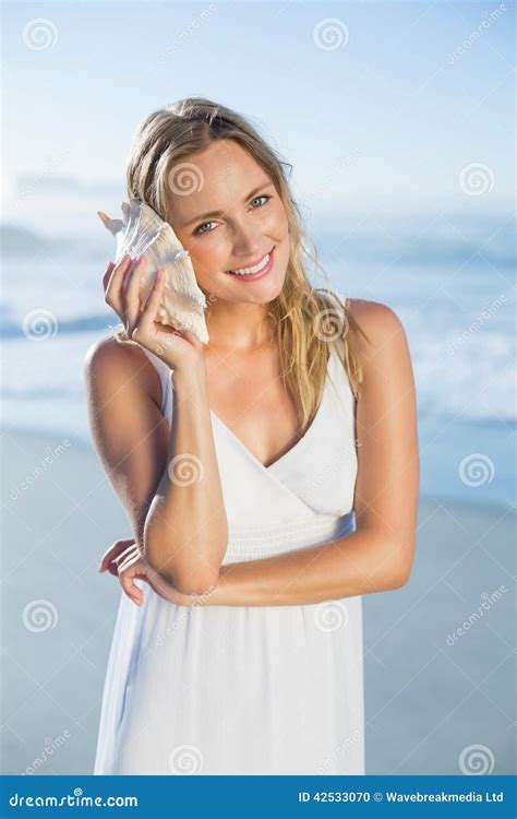 Pretty Blonde Standing At The Beach In White Sundress Listening To