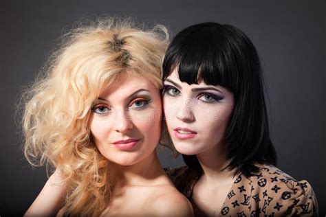 duas lésbica atrativas novas que beijam no backgroun cinzento foto de stock imagem de