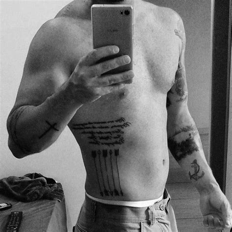 The rib cage is the arrangement of ribs attached to the vertebral column and sternum in the thorax of most vertebrates, that encloses and protects the vital organs such as the heart, lungs and great vessels. 50 Small Arrow Tattoos For Men - Manly Design Ideas