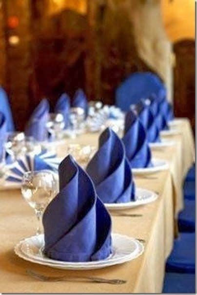 the table is set with blue napkins and place settings for dinner guests