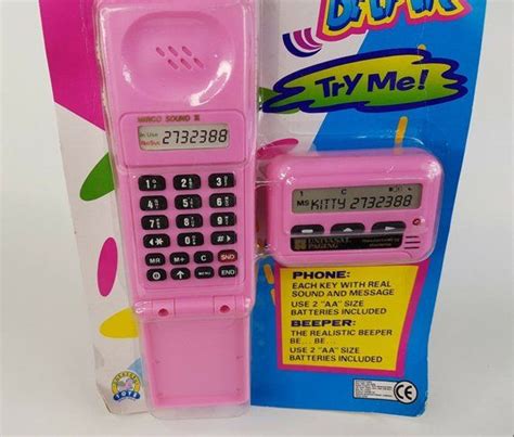 A Pink Toy Phone Sitting In Front Of A Package