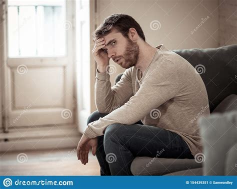 Young Man Suffering From Depression Hopeless And Alone At Home Stock