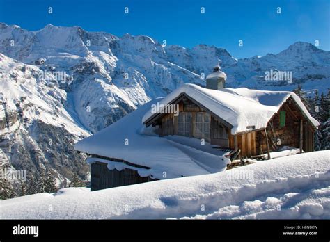 Small Snow Covered Cottage In The Mountains Of The Switzerland Alps