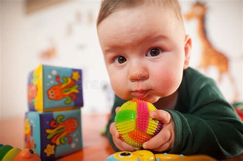 Portrait Of Cute Baby Boy Playing With Colorful Toys At Home Stock