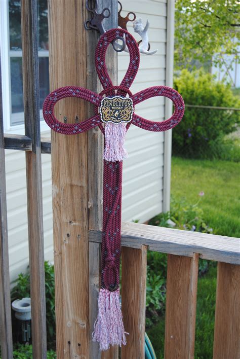 A Cross Made Out Of Rope On The Side Of A House With An Animal Head