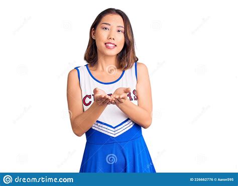 Young Beautiful Chinese Girl Wearing Cheerleader Uniform Smiling With