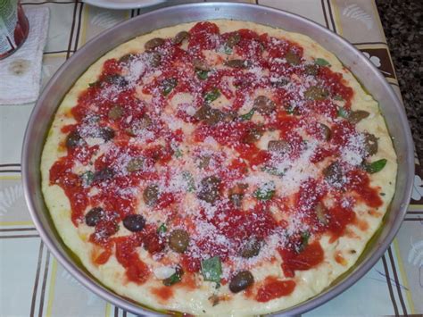 Ungete una teglia con un po' di olio extravergine d'oliva e stendete leggermente l'impasto per la seconda lievitazione, oppure formate dei panetti se volete realizzare delle pizze singole, quindi mettetelo all'interno del forno spento a lievitare per almeno 1 ora e mezza. Pizza in teglia fatta in casa - Nonnastella.com