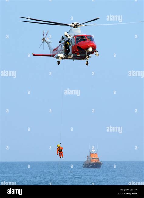 Coastguard Search And Rescue Helicopter Winch Man And Rnli Lifeboat