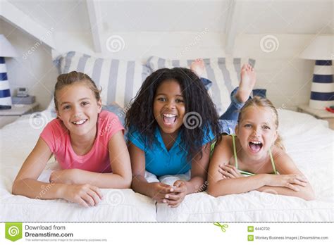 Three Young Friends Lying Down Next To Each Other Stock