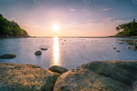 Long Exposure Image Of Dramatic Sky Seascape With Rock In Sunset Or