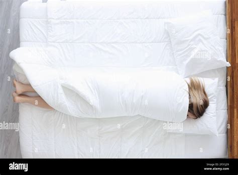 Sleeping Woman Lies On Bed Wrapped In Blanket Stock Photo Alamy