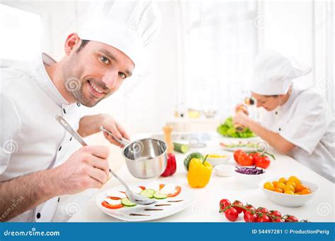 Young Attractive Professional Chef Cooking In His Kitchen Stock Image