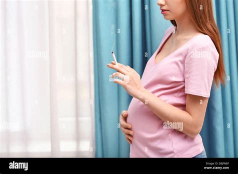 Pregnant Woman Smoking Cigarette Near Window At Home Stock Photo Alamy