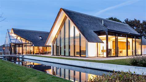 maas architecten merges a thatched cottage with a glass greenhouse