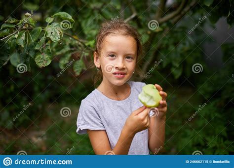 Cute Little Girl Eat Green Apple In Home Garden Outdoor Happy Child