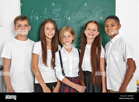 Schoolchildren Standing In Classroom Near Blackboard Stock Photo Alamy