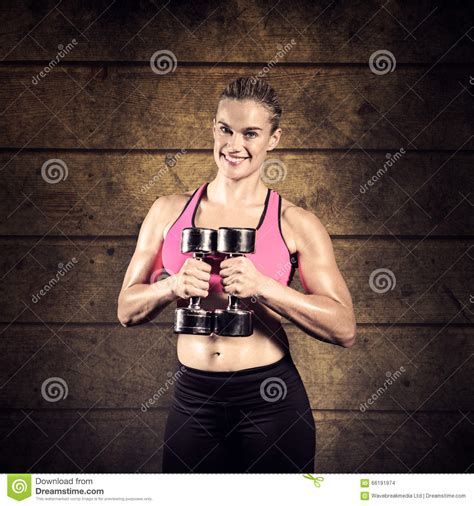 Composite Image Of Muscular Woman Lifting Heavy Dumbbells Stock Photo