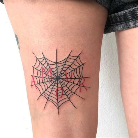 A Heart Shaped Spider Web And A Word ‘amour Inked On The Left Thigh By