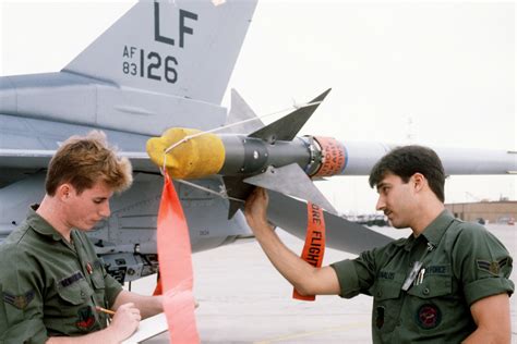 Two Armament Specialists Check The Aim 9 Sidewinder Missile On The Wing