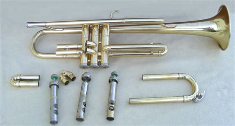 A Brass Trumpet And Other Musical Instruments Are Laid Out On A White
