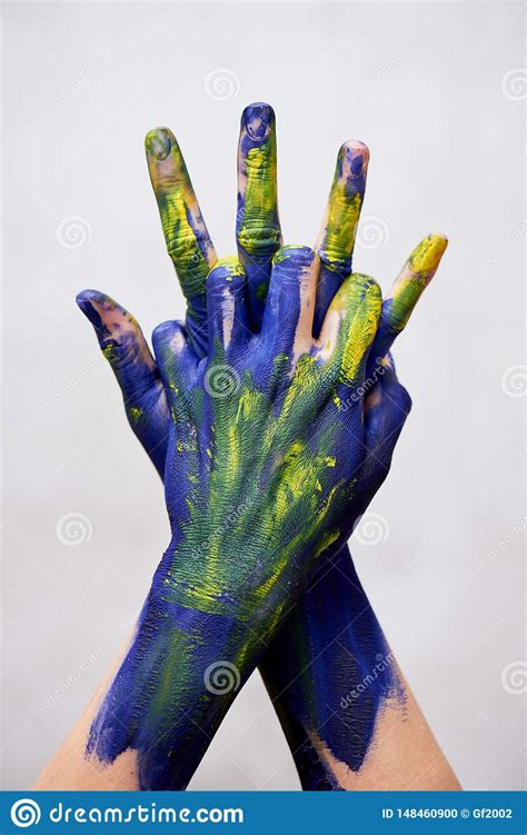 Graceful Hands Of The Artist Hands In Blue And Yellow Paint Creator