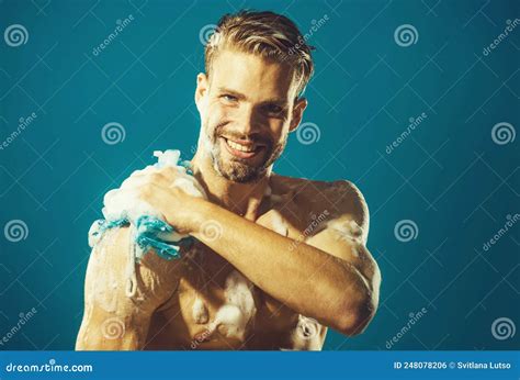 Smiling Man Washing Body With Moisturizing Gel And Washcloth Taking