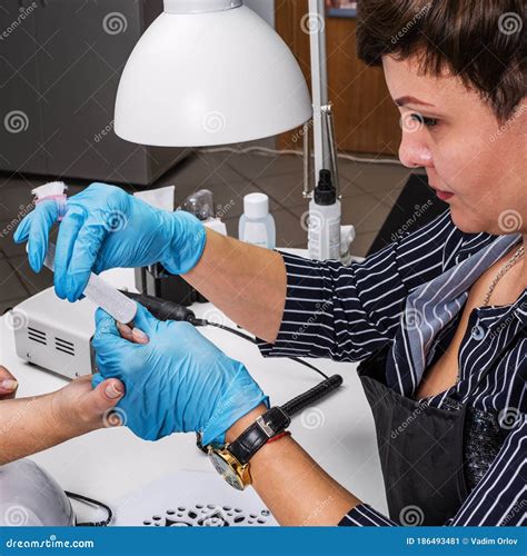 Nail Salon, Hands of Client and Master. Nail Treatment with a Manicure