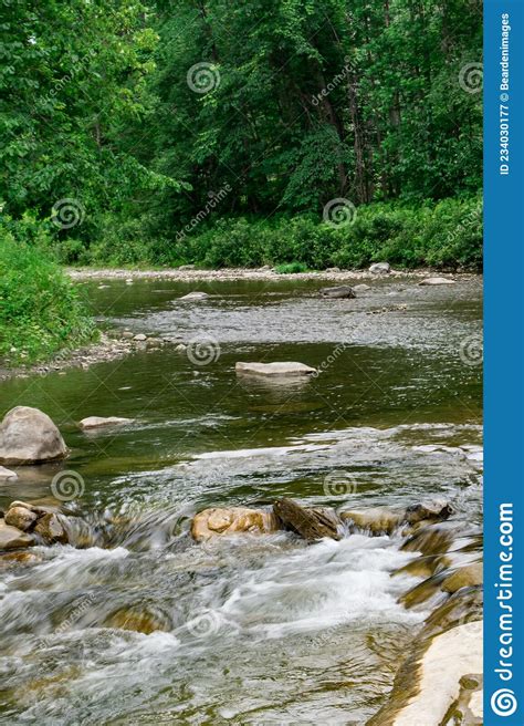 Serene Vermont River Flowing Through The Lush Forest Stock Image