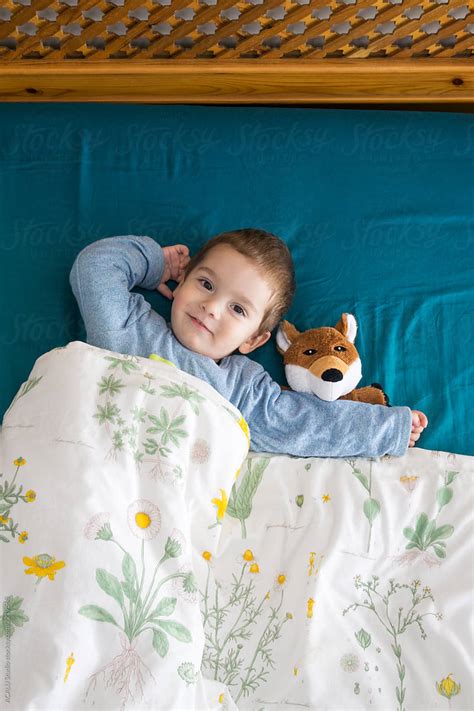 Baby Lying On The Bed With His Stuffed Toy Del Colaborador De Stocksy