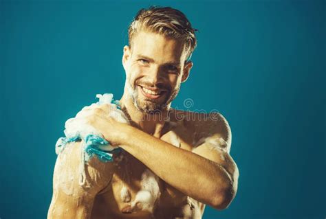 Smiling Man Washing Body With Moisturizing Gel And Washcloth Taking