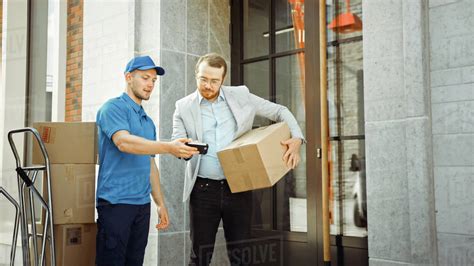 Delivery Man Gives Postal Package To A Business Customer Who Signs