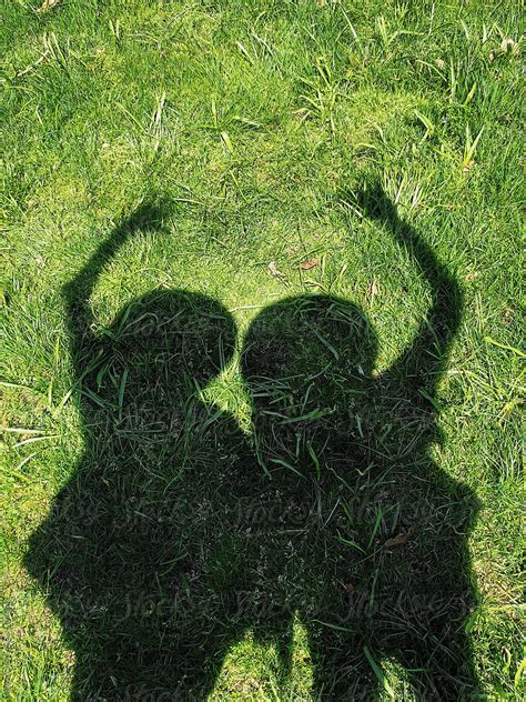 Shadow Of Two Women On Green Grass Waving Hello Del Colaborador De