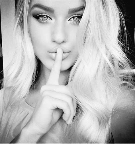 A Black And White Photo Of A Woman With Her Finger On Her Lips Looking