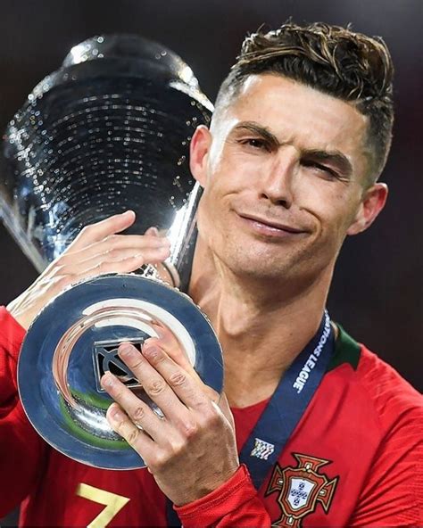 A Man Holding Up A Trophy In His Right Hand And Wearing A Red Shirt On