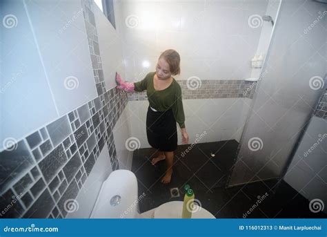 Asian Female Maid Or Housekeeper Cleaning On Toilet Wall Stock Image