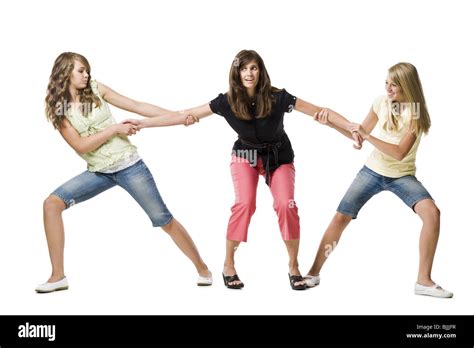Two Girls Pulling Mothers Arms In Both Directions Stock Photo Alamy