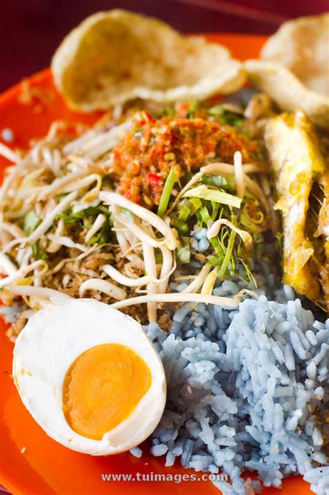 There is the blue rice, a fried fish in this recipe, we used laksa leaves, torch ginger flower and lemongrass in our herb salad but traditionally, people preparing it at home would. stock images nasi kerabu, kelantan food stock photos