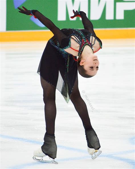 A Female Figure Skating On The Ice In A Black Outfit And Tights With