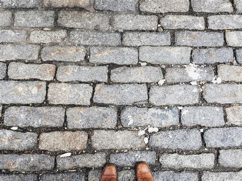 Overhead View Of Feet Standing On Belgian Pavers By Stocksy Contributor Holly Clark Stocksy
