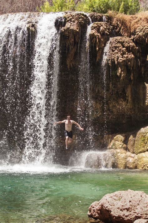 Man Jumping From Havasu Falls At Grand Canyon National Park Stock Photo