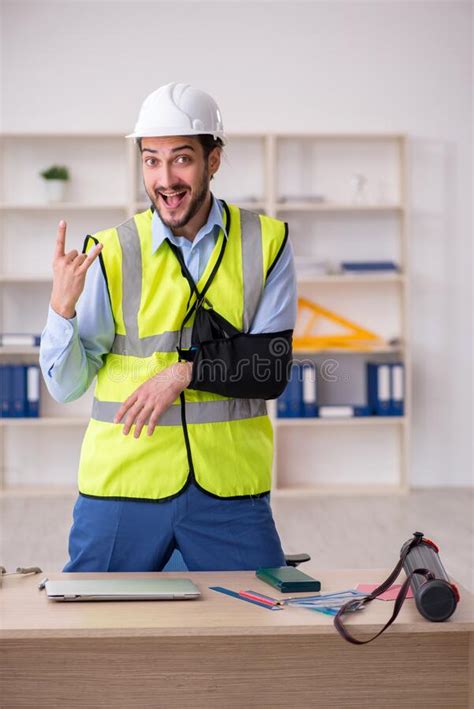 Young Arm Injured Male Architect Working In The Office Stock Photo