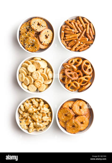 Mixed Salty Snack Crackers And Pretzels In Bowls Isolated On White