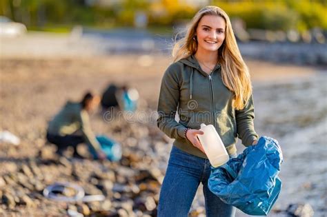 Volunteer Holding Bottle And Garbage Bag At Beach Stock Photo Image