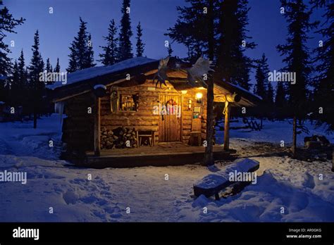 Interior Alaska Log Cabin Forest Winter Porch Light Snow Sky Dusk Stock