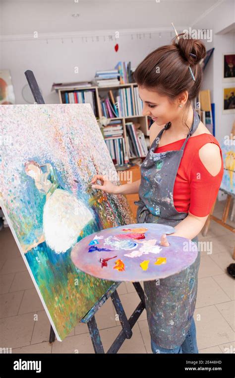 Vertical Shot Of A Female Artist Working On A Painting On Canvas At Art