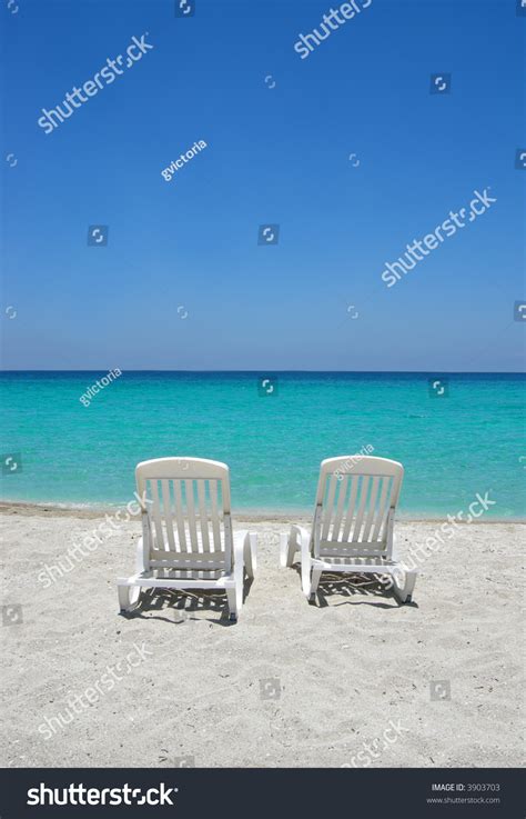 Empty Tropical Beach Chairs On Sand At Shoreline In The Caribbean Stock